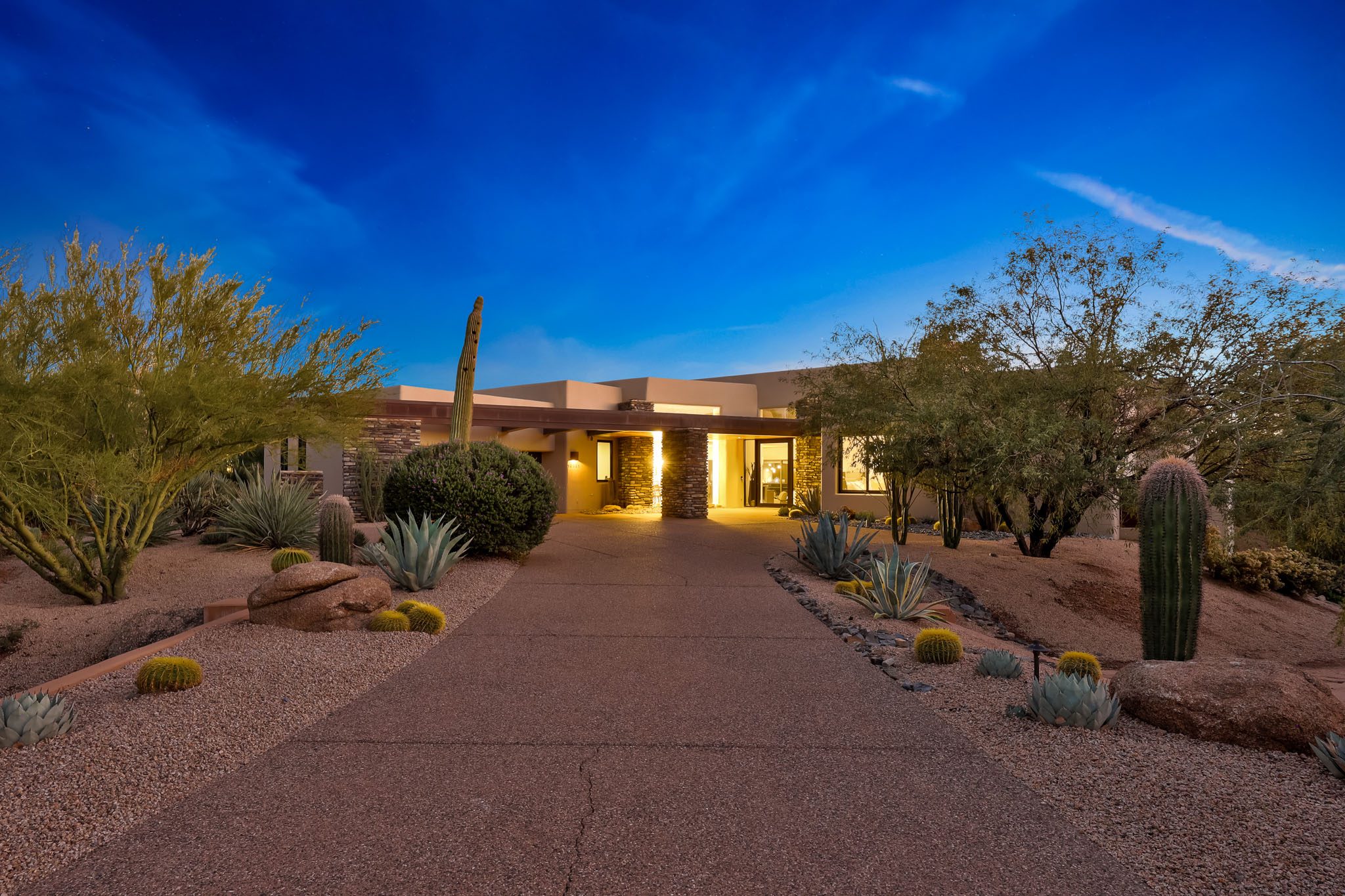 Front entry at twilight — stone columns, designer landscape