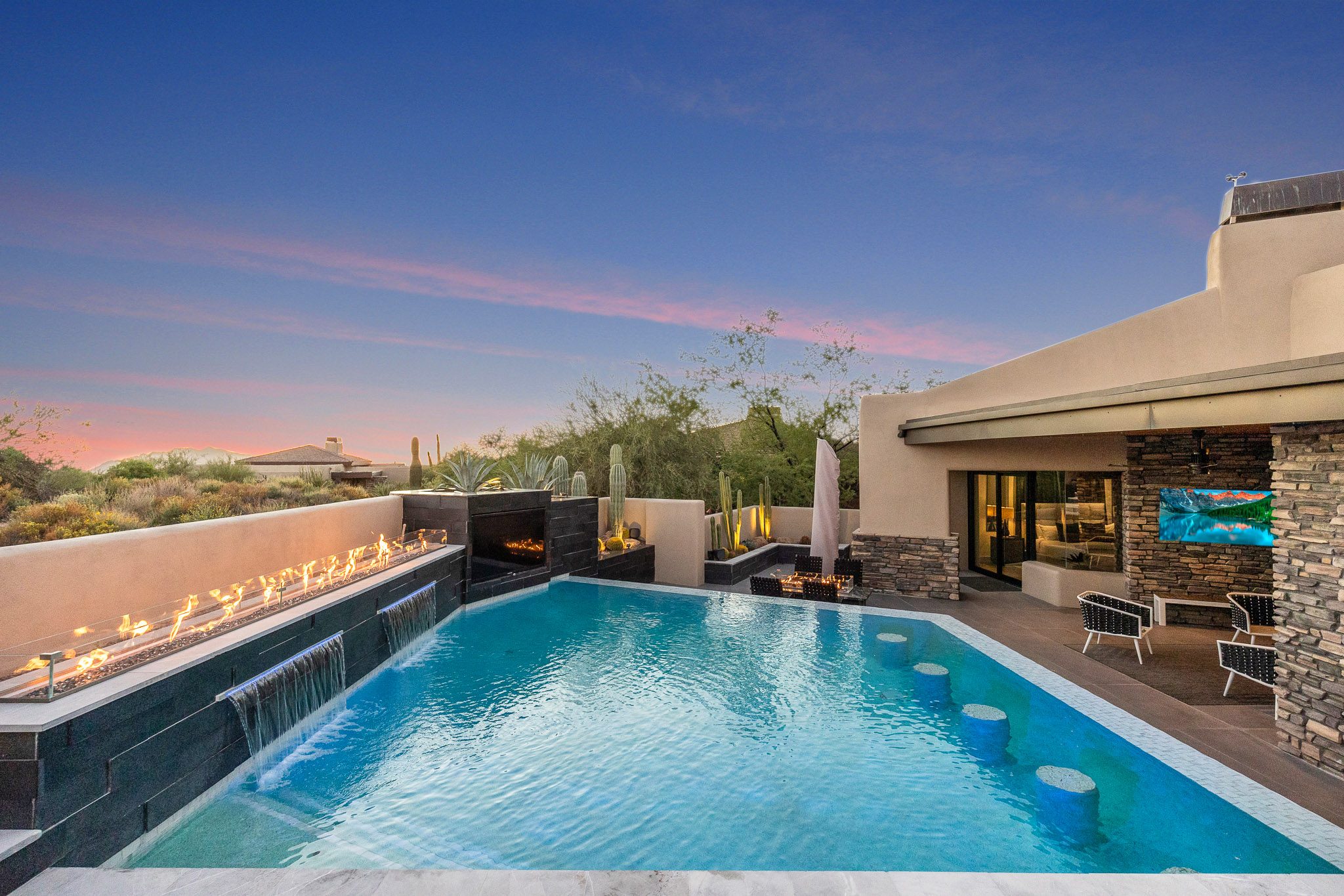 Pool with fire features and outdoor living at twilight