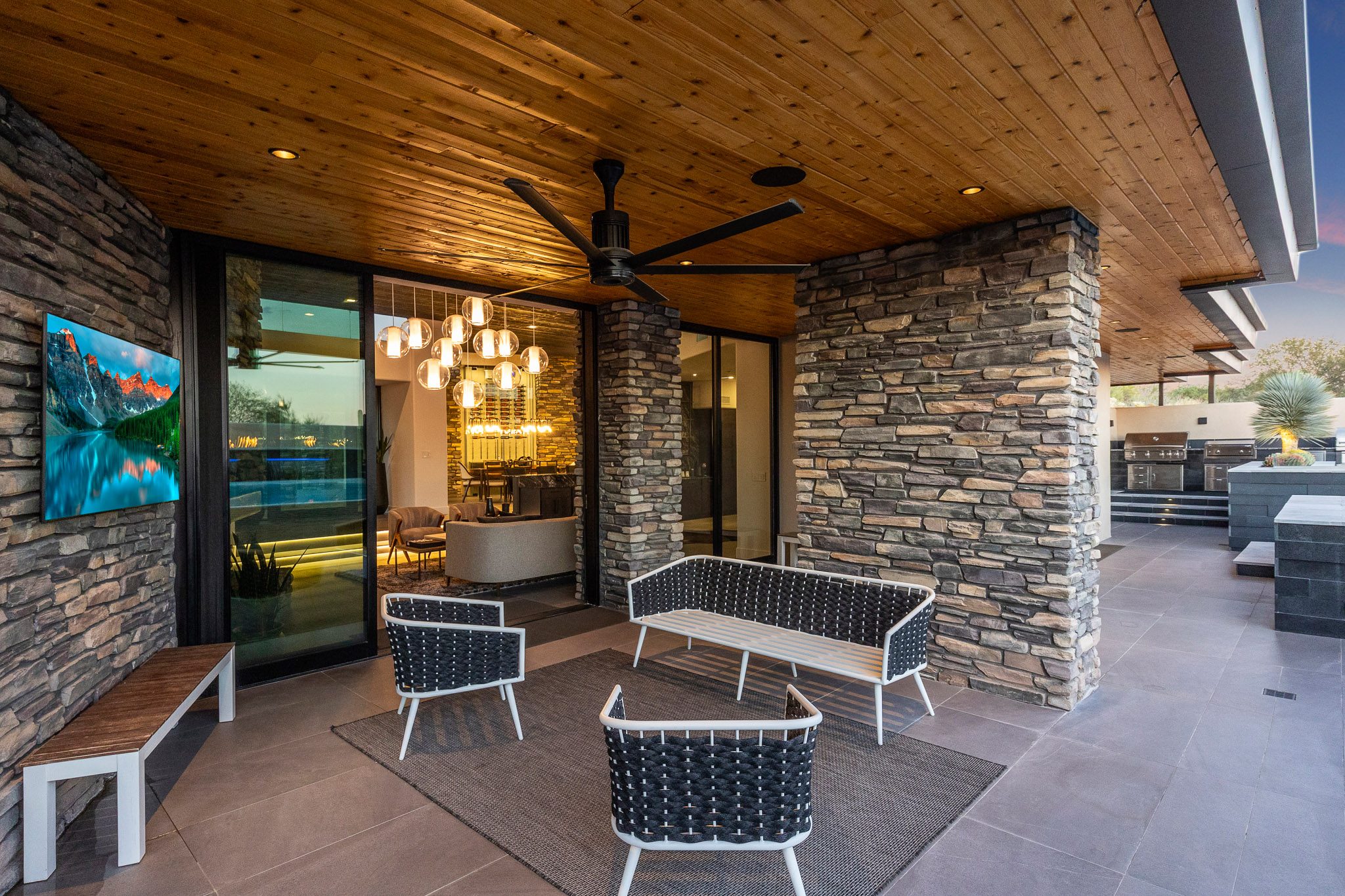 Covered patio with stacked stone and wood ceiling