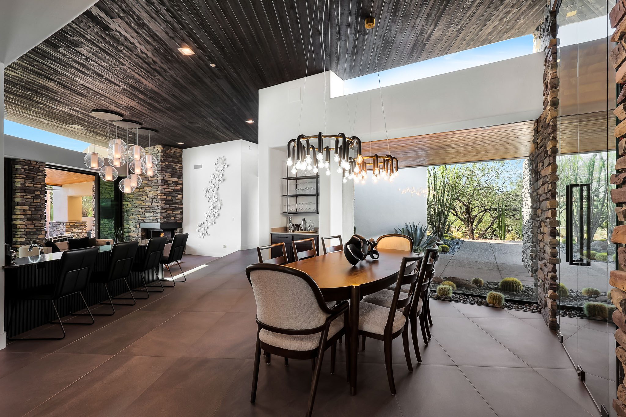 Dining room with stacked stone columns and statement lighting