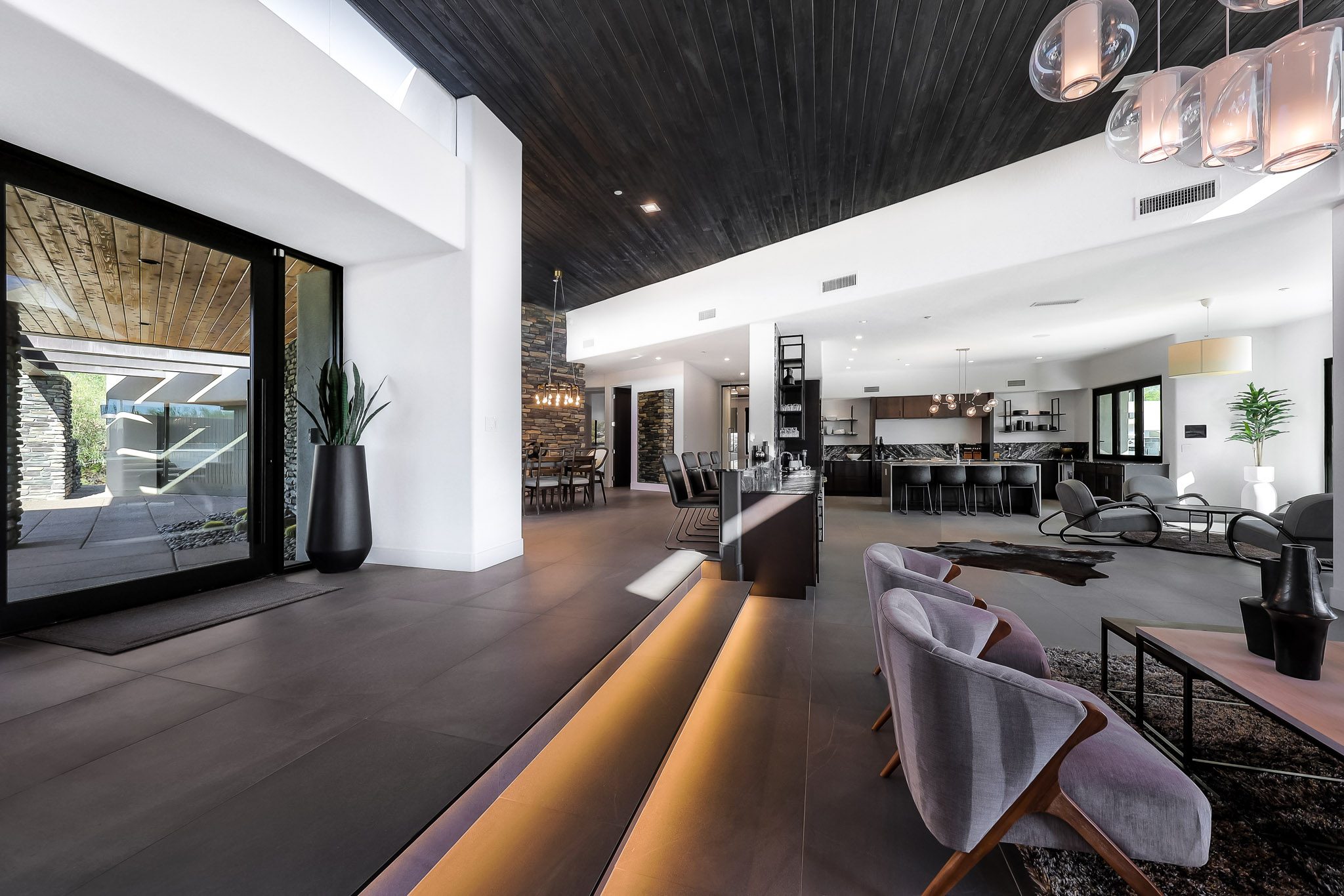 Great room with dark wood ceiling and floor lighting